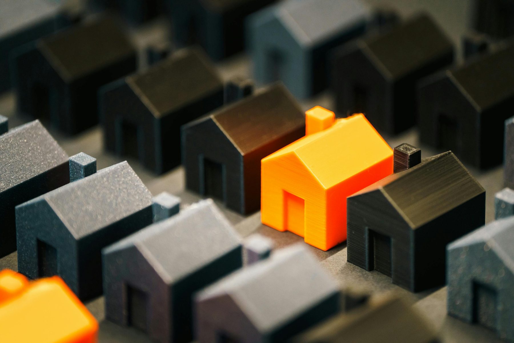 A field of house models. One stands apart.