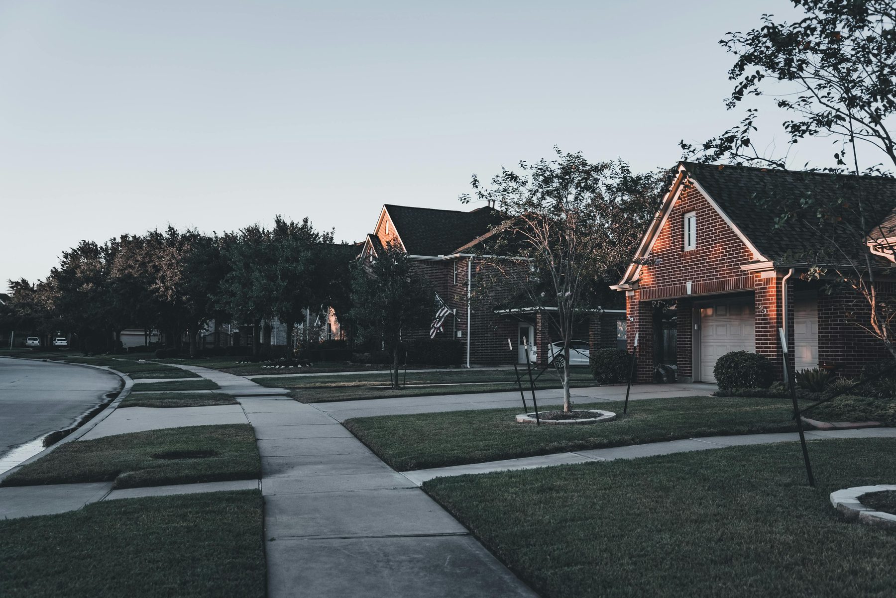 A quiet street of homes at dusk.