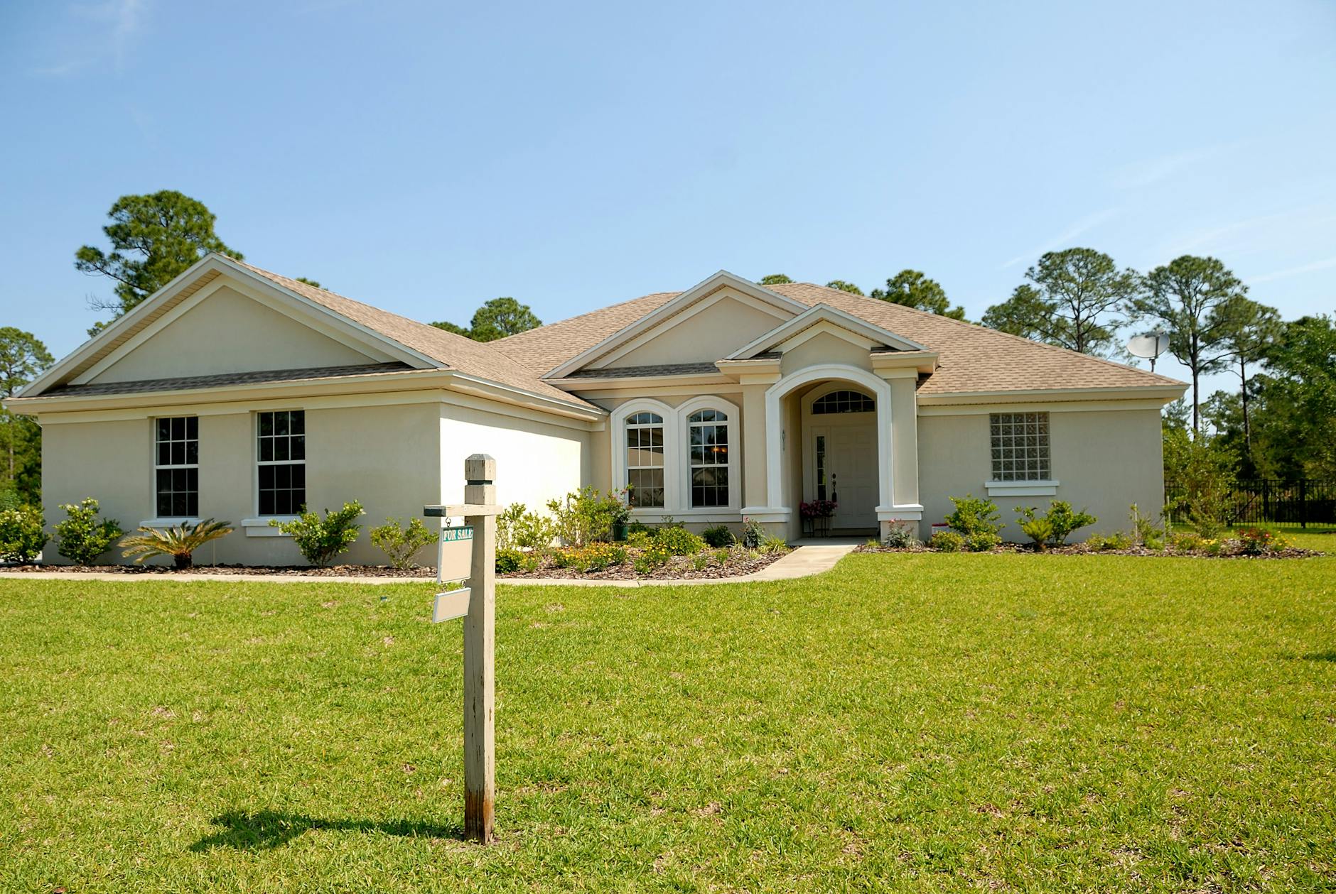 A two-story brick house with a wide front lawn and a concrete driveway.