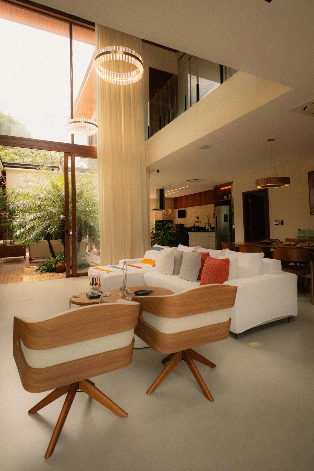A modern white house with a covered porch and a landscaped front yard.